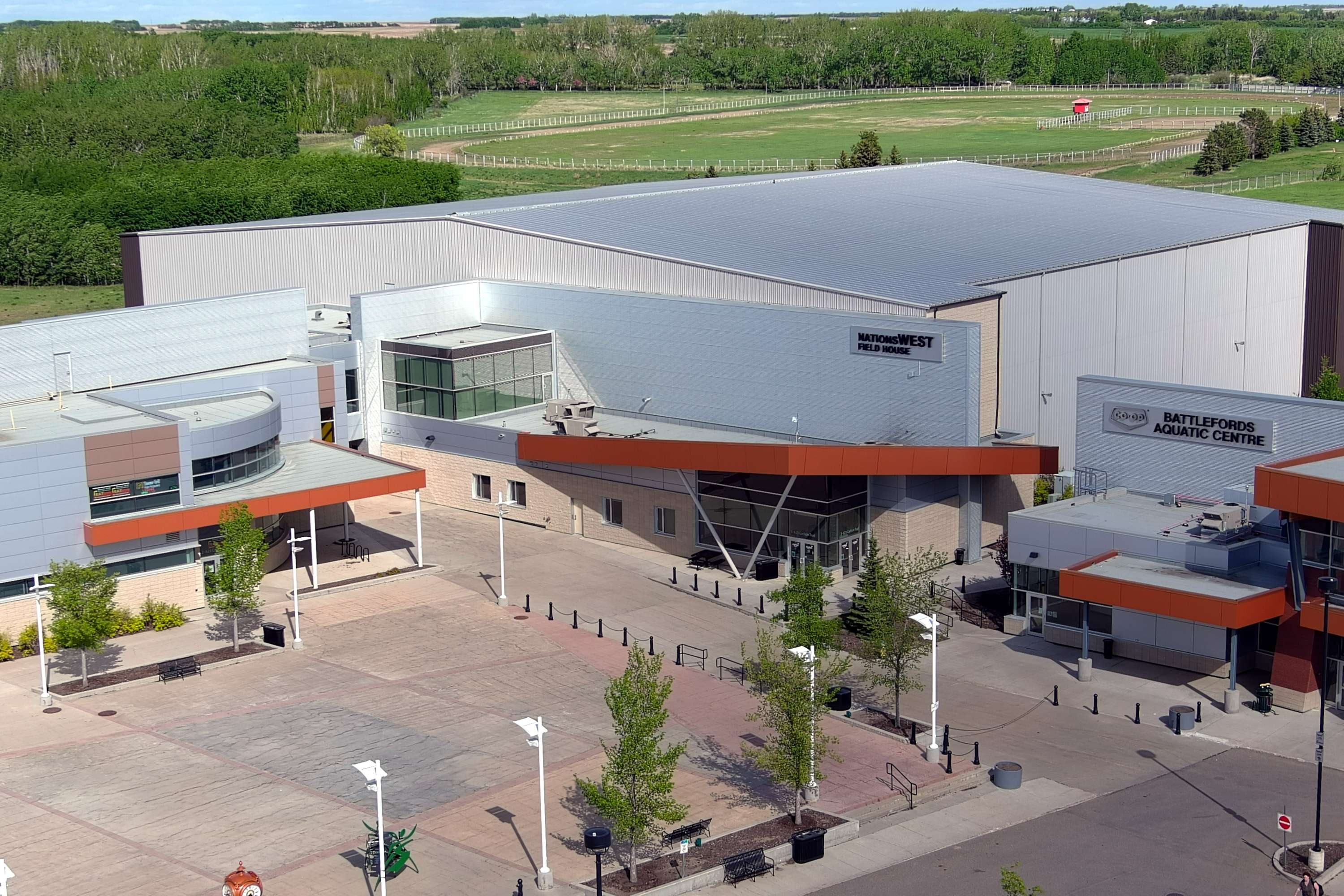 An aerial view of the NationsWEST Field House with a green field in the background.