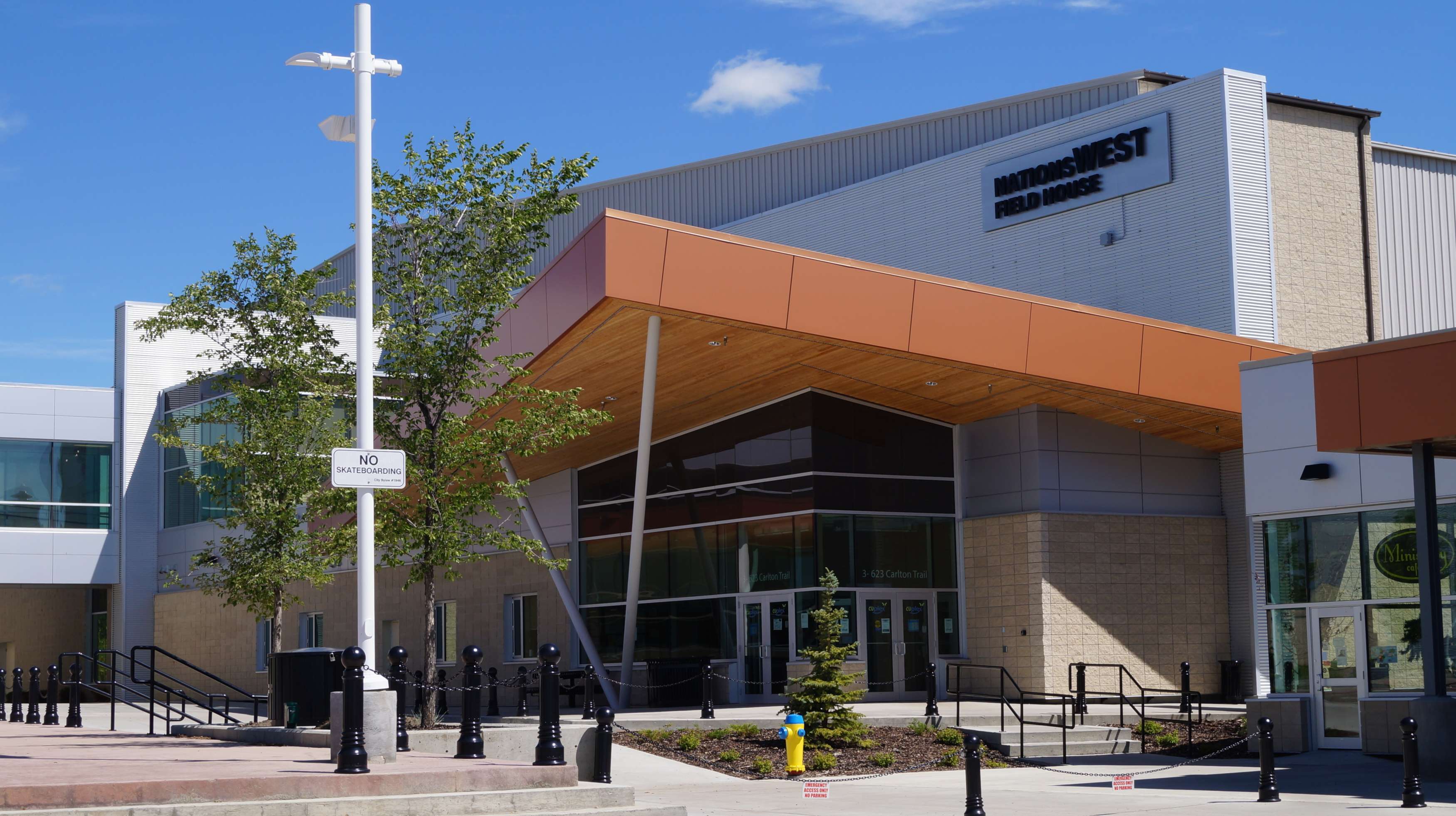 Front entrance of NationWEST Field House in summer under a blue sky.