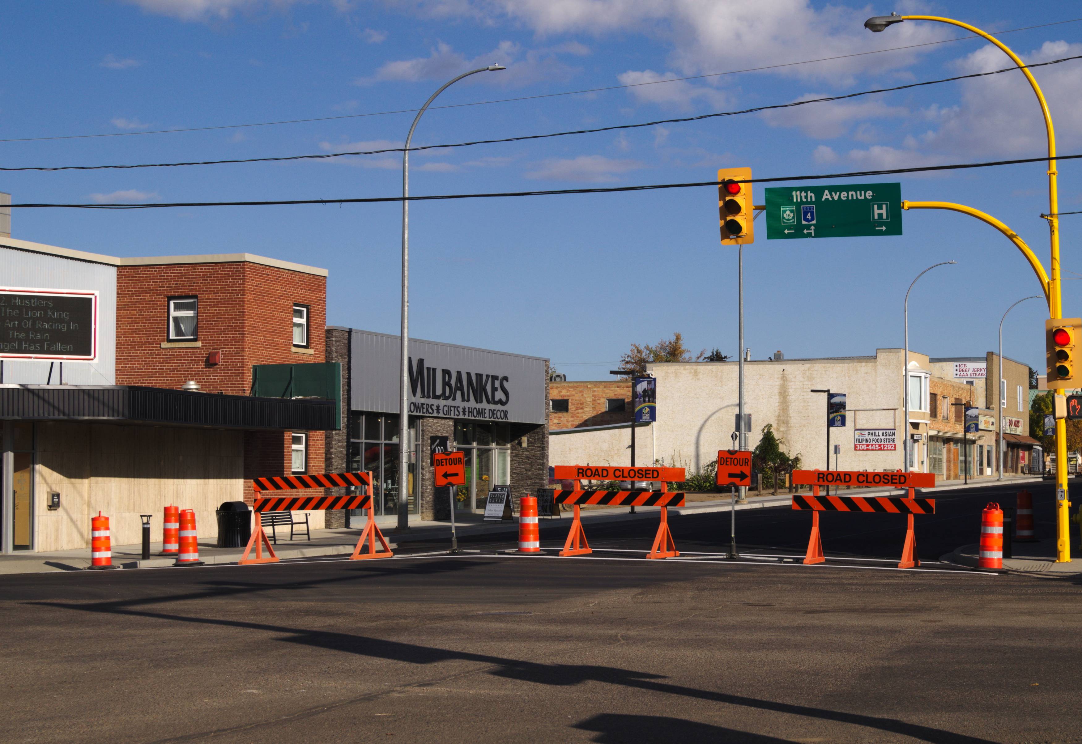 Street barricades block access to 100th Street from 11th Avenue in downtown, indicating a closure.